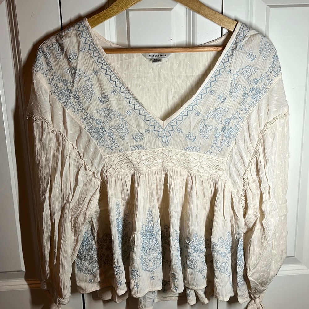 American Eagle. Small. White blouse with blue embroidery.